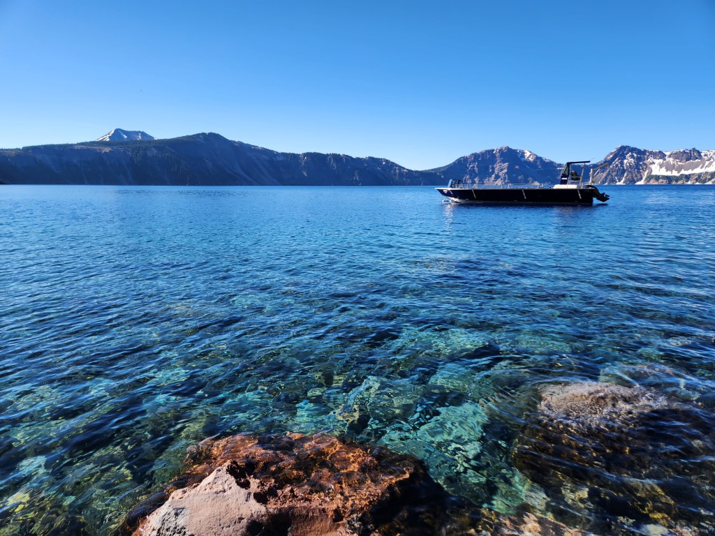 Boat floating in blue water in Cleetwood Cove